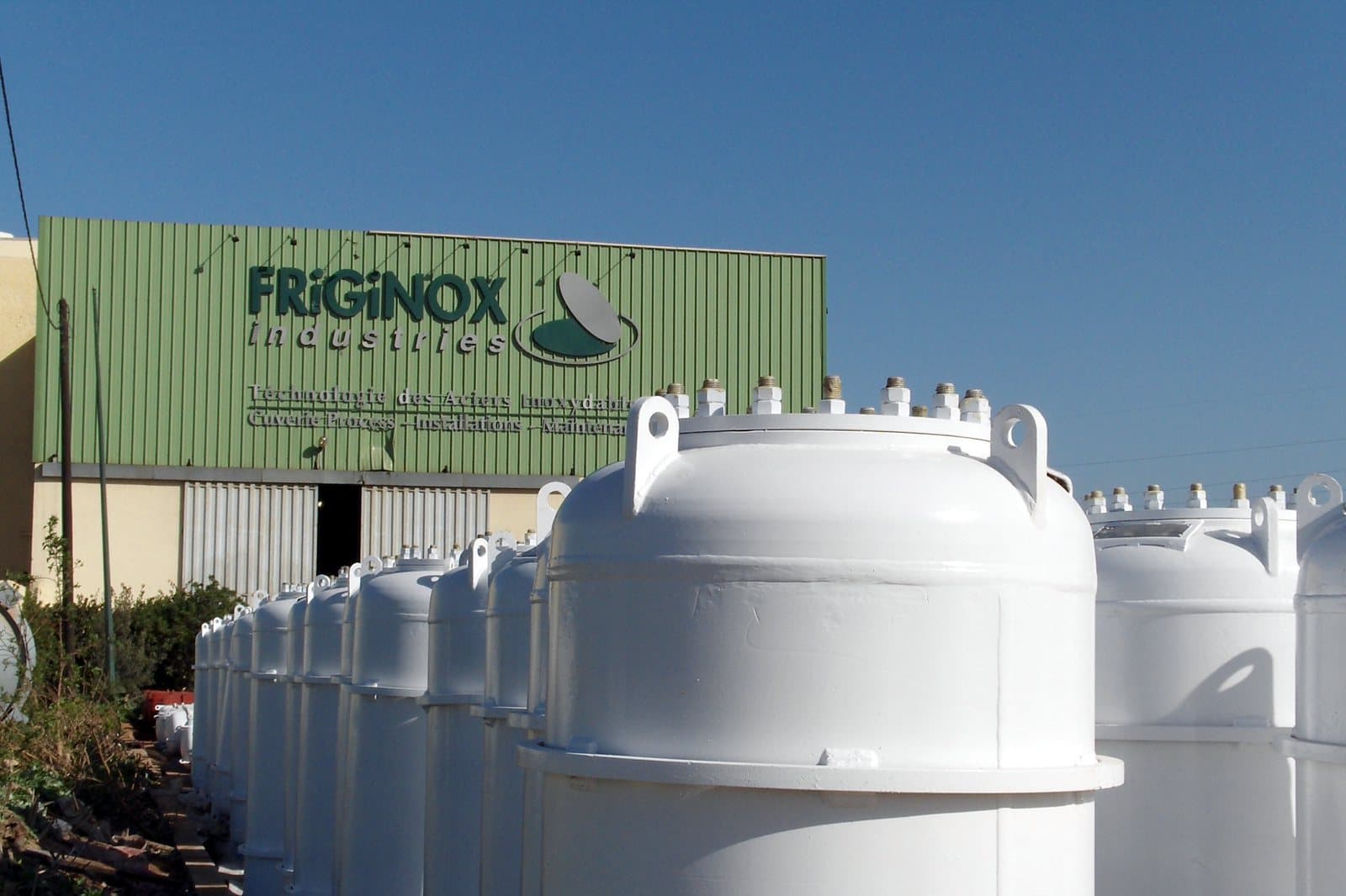 Rangées de réservoirs à chlore sous pression, peints en blanc, alignés devant l’atelier Friginox